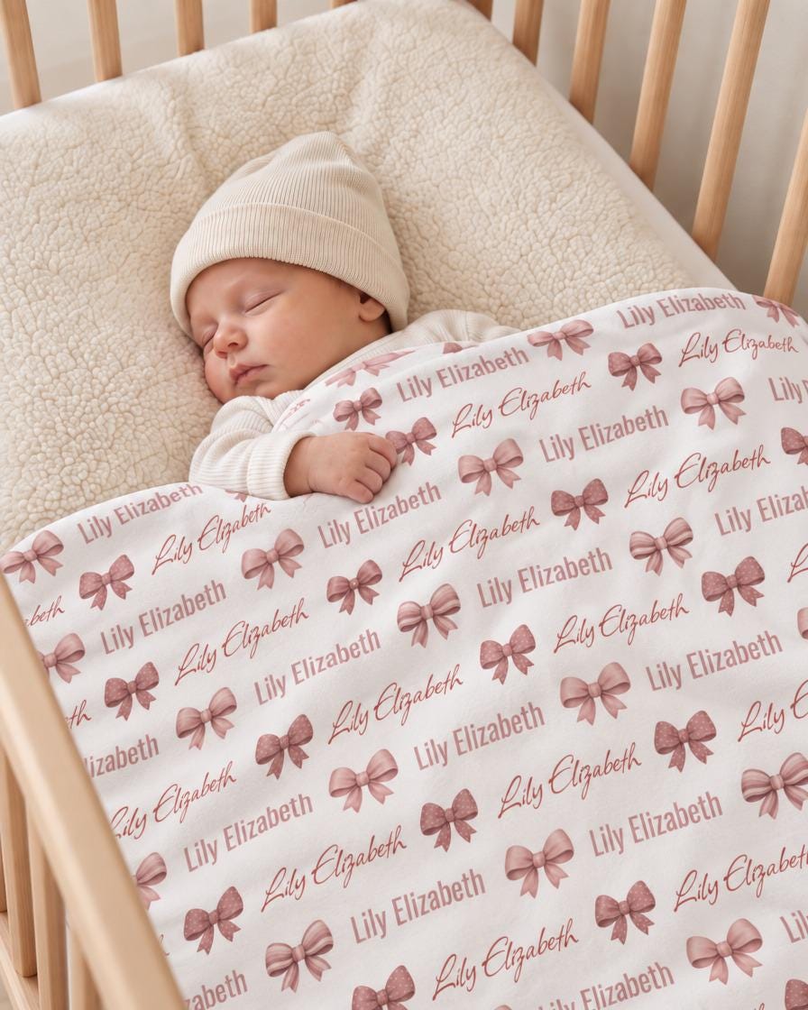 Sleeping baby under personalized bow name blanket