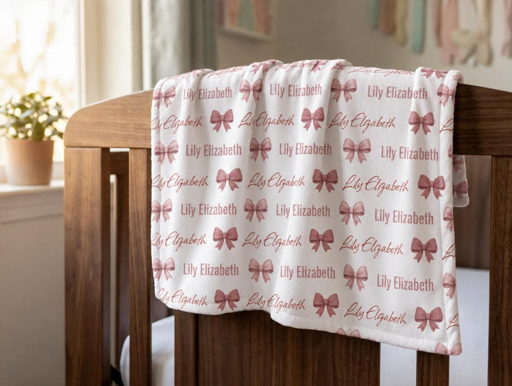 Personalized bow fleece blanket draped over crib rail